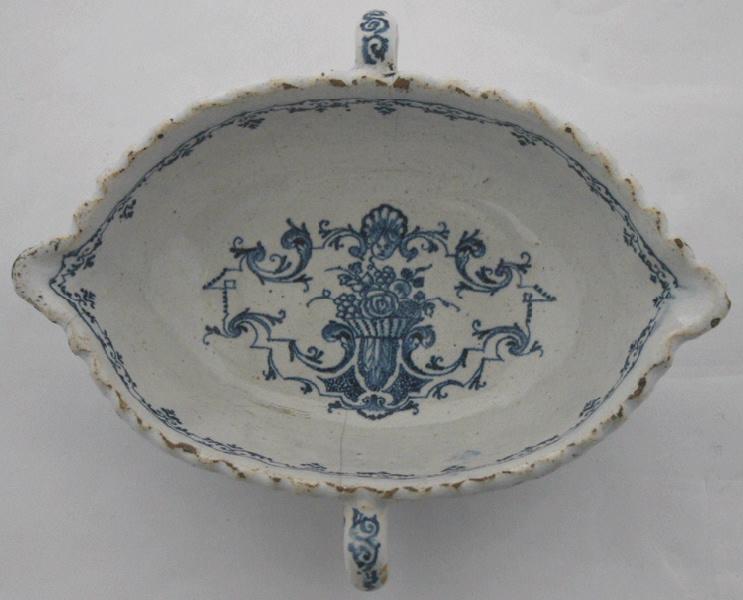 Saucière ovale à décor d'arabesques et d'une corbeille de fleurs