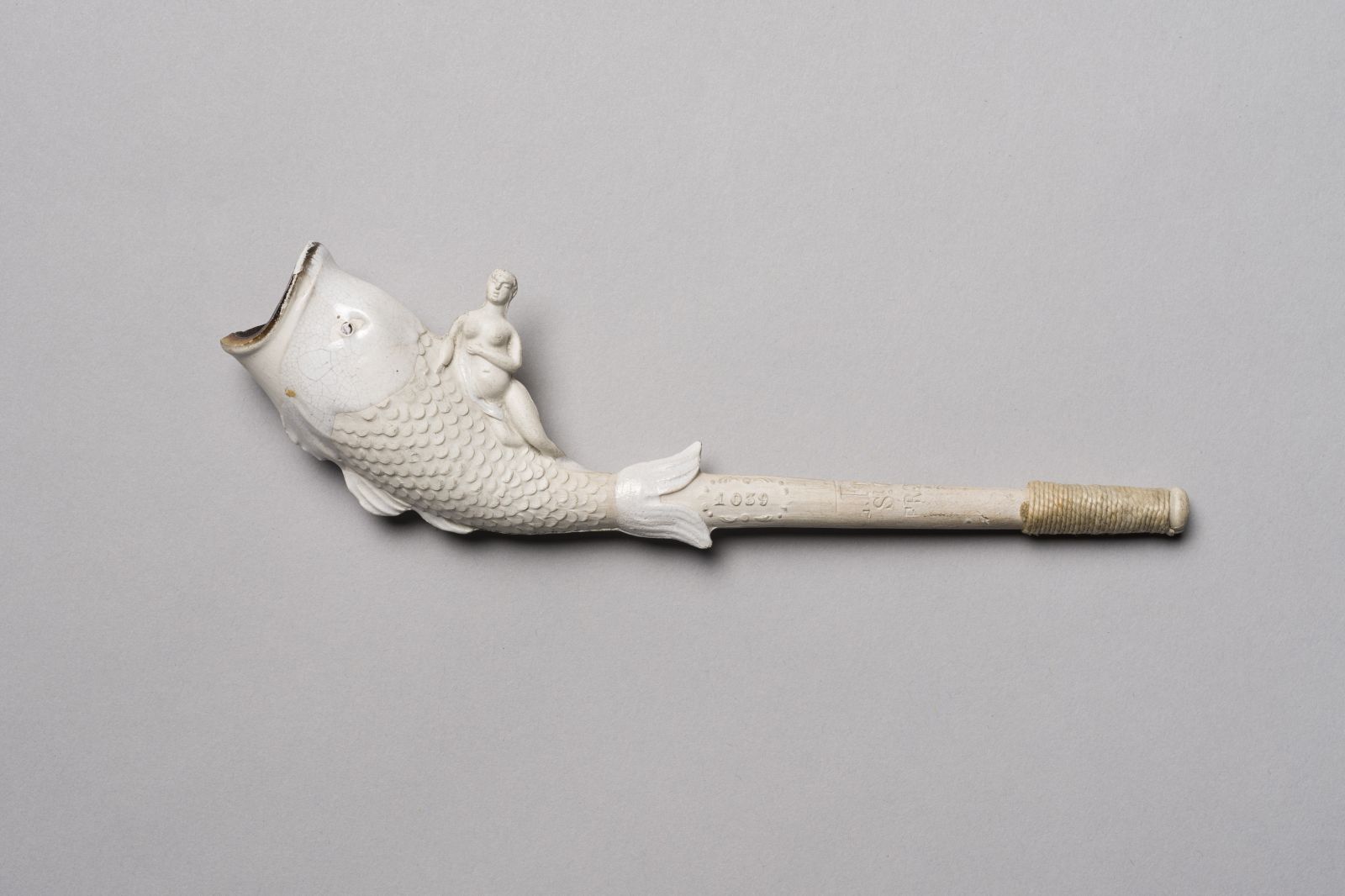 Tête de pipe en forme de poissons surmontée d'une femme