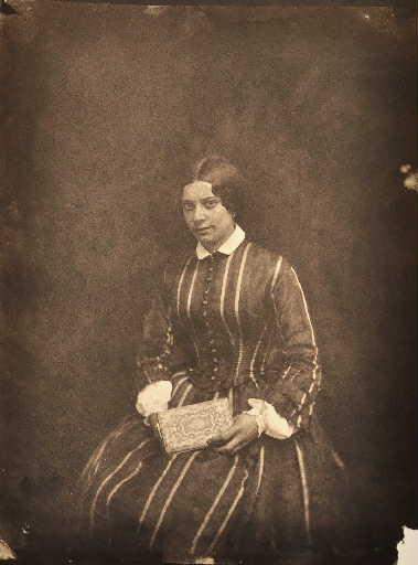 Femme assise tenant un livre