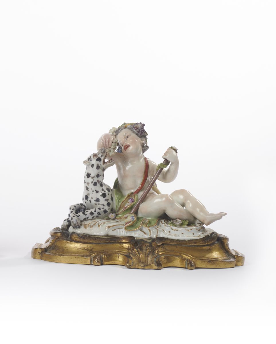 Statuette représentant un jeune faune assis à terre ayant à côté de lui un chien à peau tachetée de noir