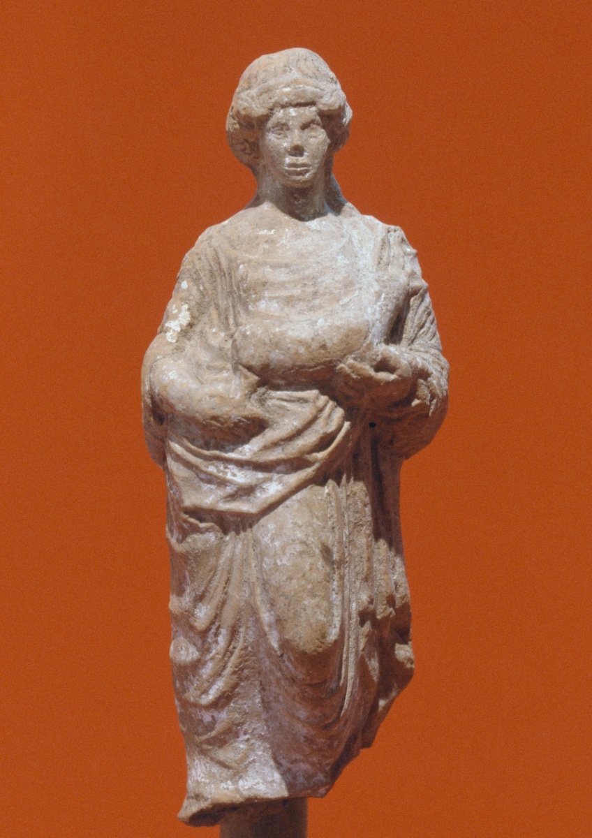 Femme drapée debout offrant un porcelet