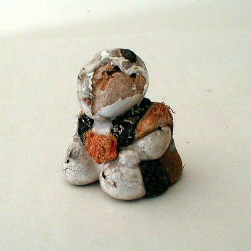 Poupée en bois et tissu représentant un personnage agenouillé les mains sur les genoux