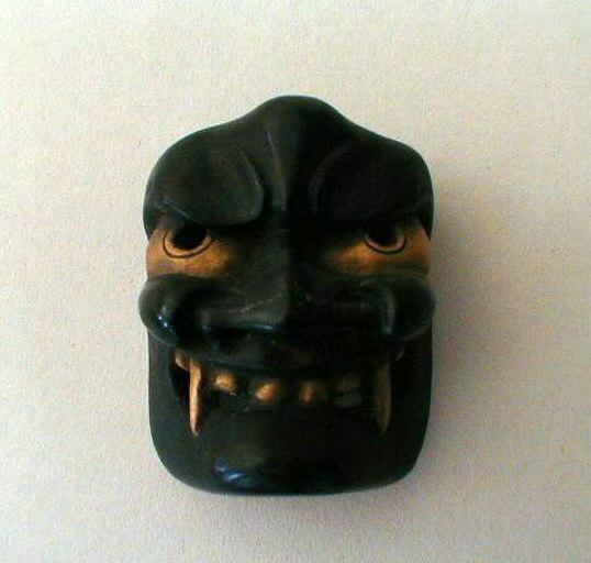 Netsuké en ébène laqué représentant un masque chimérique