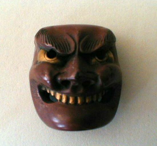 Netsuké en bois laqué représentant un masque grotesque riant