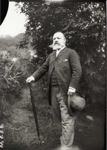 Portrait d'archéologue. Edouard Fourdrignier (1842-1907) en appui sur un parapluie tenant un chapeau