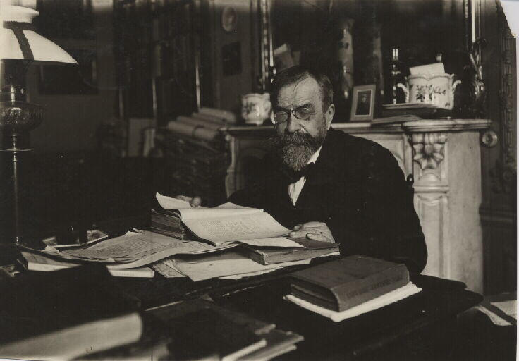 Portrait d'archéologue. Portrait de Camille Jullian (1859-1933) assis à sa table de travail