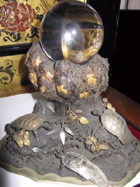 Trois tortues (Un rocher en bronze avec une boule de cristal.)