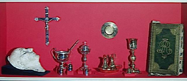 Masque mortuaire de Napoléon, plâtre (0,34 x 0,15) ; crucifix de Sainte-Hélène ; missel de Sainte-Hélène, calice et patine, buvette et navette, clochette, ciboire, bénitier, goupillon, 3 ampoules