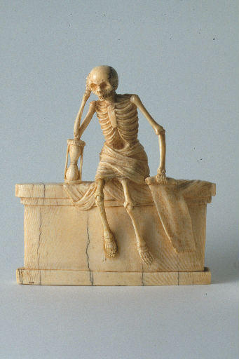 Squelette dans un linceul assis sur un tombeau