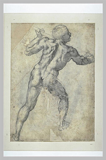 Homme debout, de dos, tenant un baton