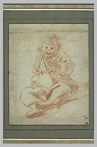 Un enfant assis, vu de face, en train de manger