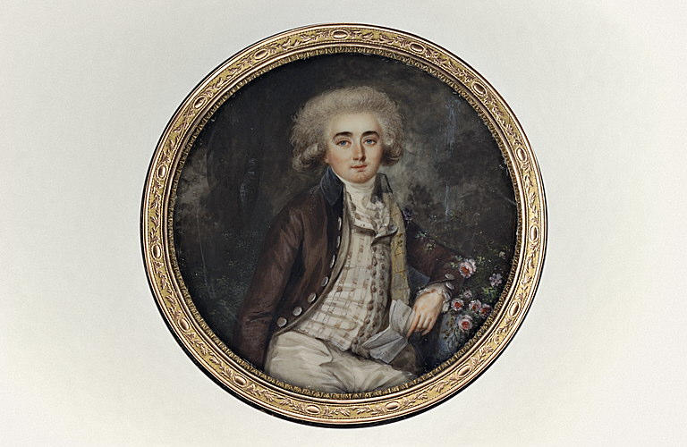 Jeune homme assis dans un parc tenant une lettre