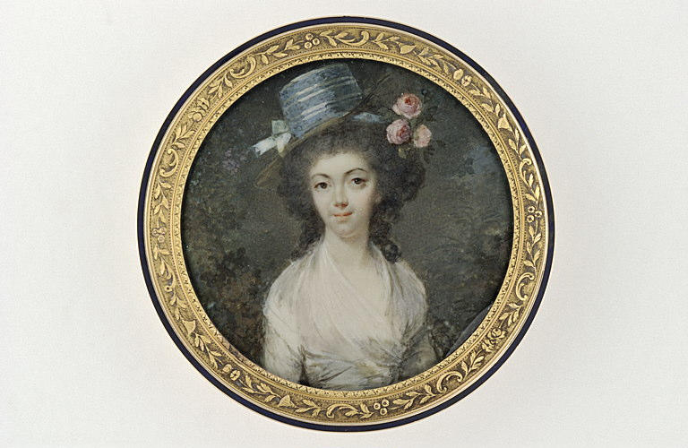 Une jeune femme brune coiffée d'un chapeau bleu