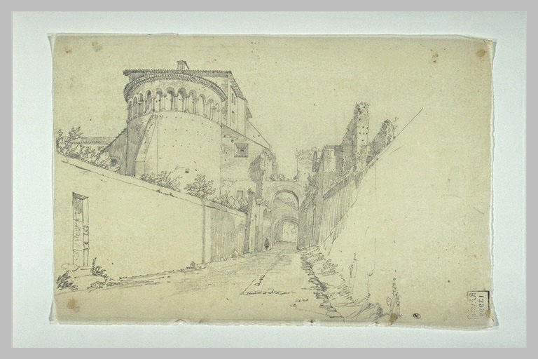 Chemin entre des murs passant, au fond, sous des arcades