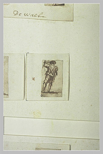 Soldat, de dos, paraissant examiner son arme