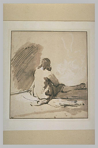 Jeune homme assis à terre, de dos, la jambe droite étendue