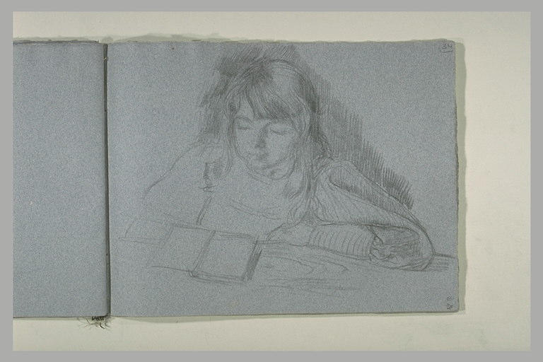 Fillette aux longs cheveux devant une table, lisant