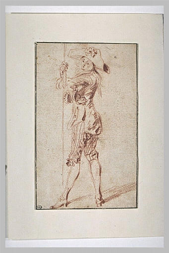 Acteur, debout, tourné vers la gauche, appuyé sur un long bâton