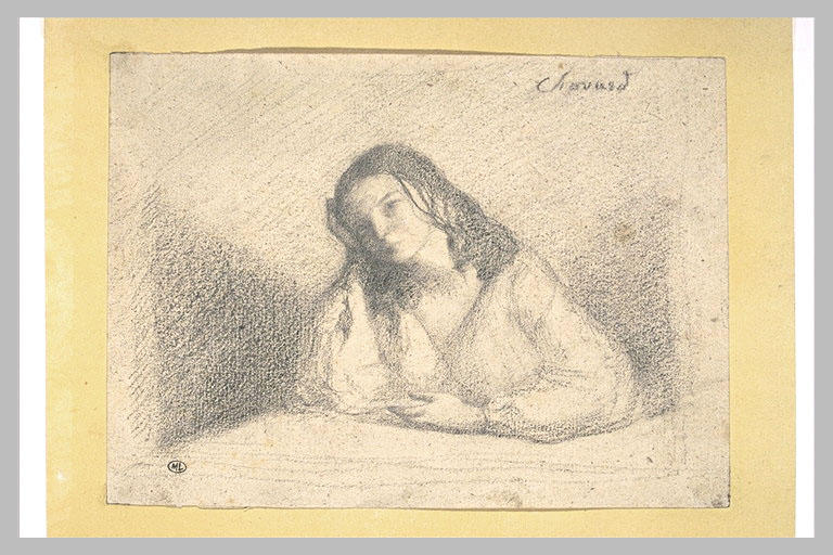 Femme assise derrière une table, de face, la tête penchée à gauche