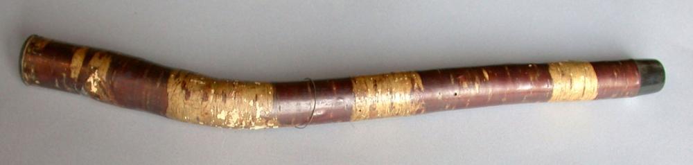 Objet coudé en bois de bambou (?) avec un orifice longitudinal. Bicolore : rouge et blanc.