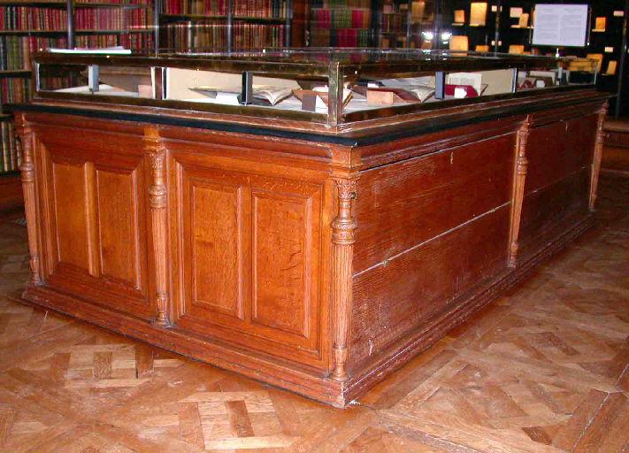 Une vitrine en bois recouvert de cuir noir formant bibliothèque basse