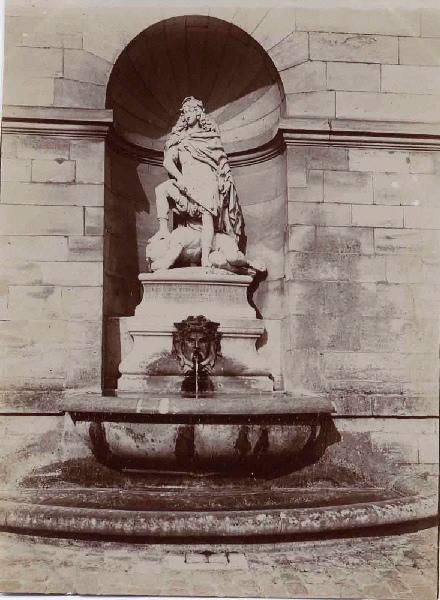 'Louis XIV terrassant la Fronde', sculpture dans la cour de la capitainerie du château de Chantilly. ; Album de 100 photographies représentant le Domaine de Chantilly après 1900, dans une reliure de chagrin vert