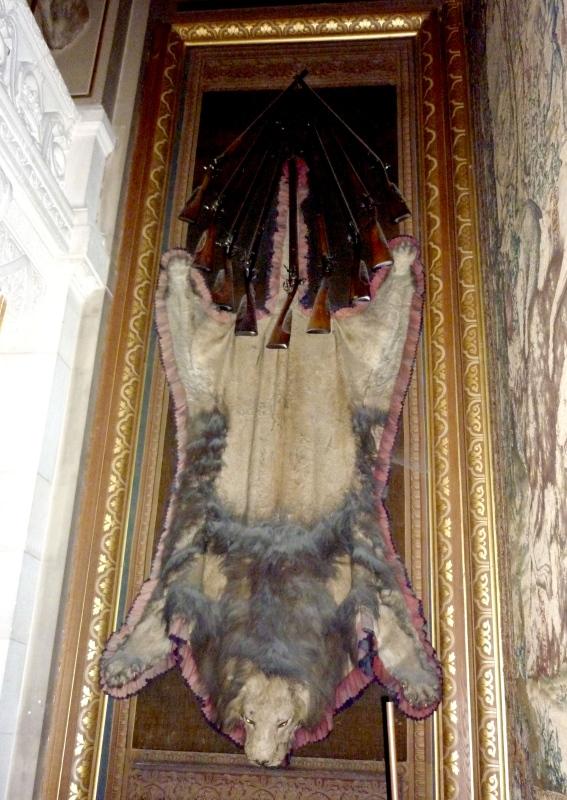 Toile peinte sur laquelle repose une peau de lion et des trophées d'armes