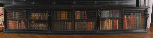Meuble de bibliothèque en bois noir recouvert de maroquin brun numérotés à portes vitrées et grillagées