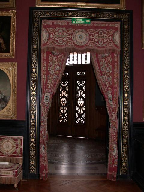 Rideau faisant en tapisserie de Beauvais, doublés de soie cerise, garnis de franges et embrasses