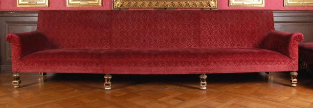 Grand canapé en bois peint en noir avec dorures, recouvert de tissu broché grenat