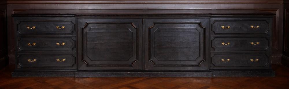 Meuble à estampes en bois noir, partie centrale ouvrant par double porte, 3 tiroirs à poignées dorées de chaque côté en décrochement