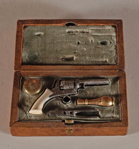 Pistolet miniature à manche d'ivoire avec accessoires (4 pièces en tout) dans sa boîte en maroquin fauve doublé de velours vert amande