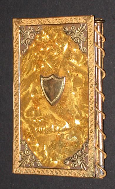 Petit carnet, monture or, plats en aventurine jonquille avec spirale pour crayon servant de fermeture. Ecusson sur le plat supérieur.