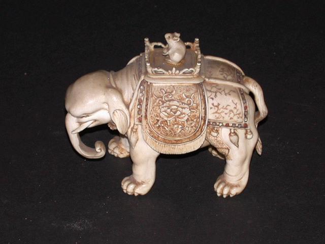 Eléphant en ivoire sculpté sur le dos duquel est posé un palanquin où est assise une souris tenant une balle dans ses pattes