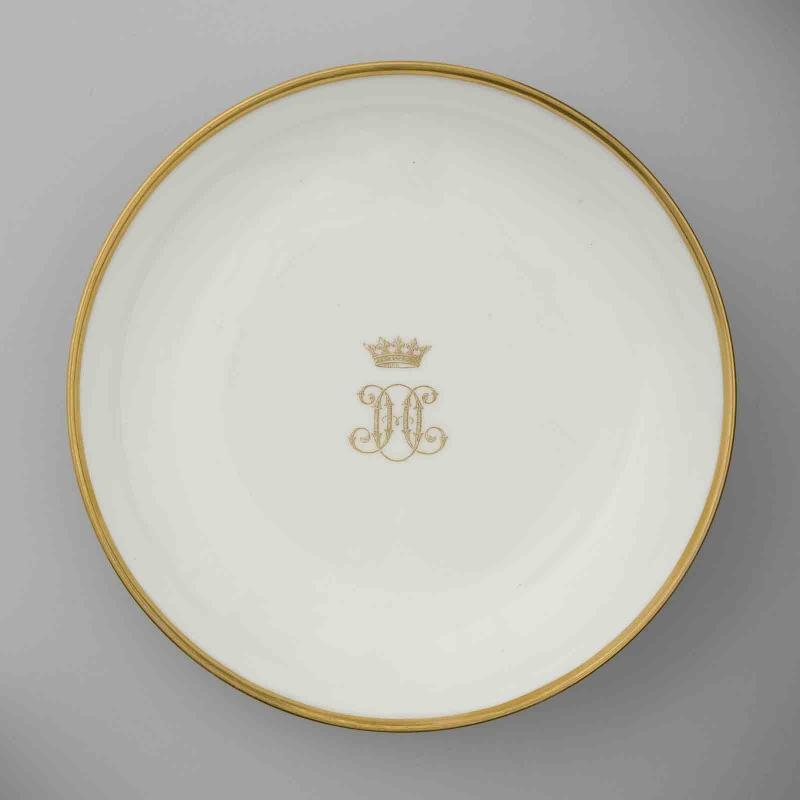 Soucoupe en porcelaine de Sèvres à marli doré au chiffre HO doré et couronné