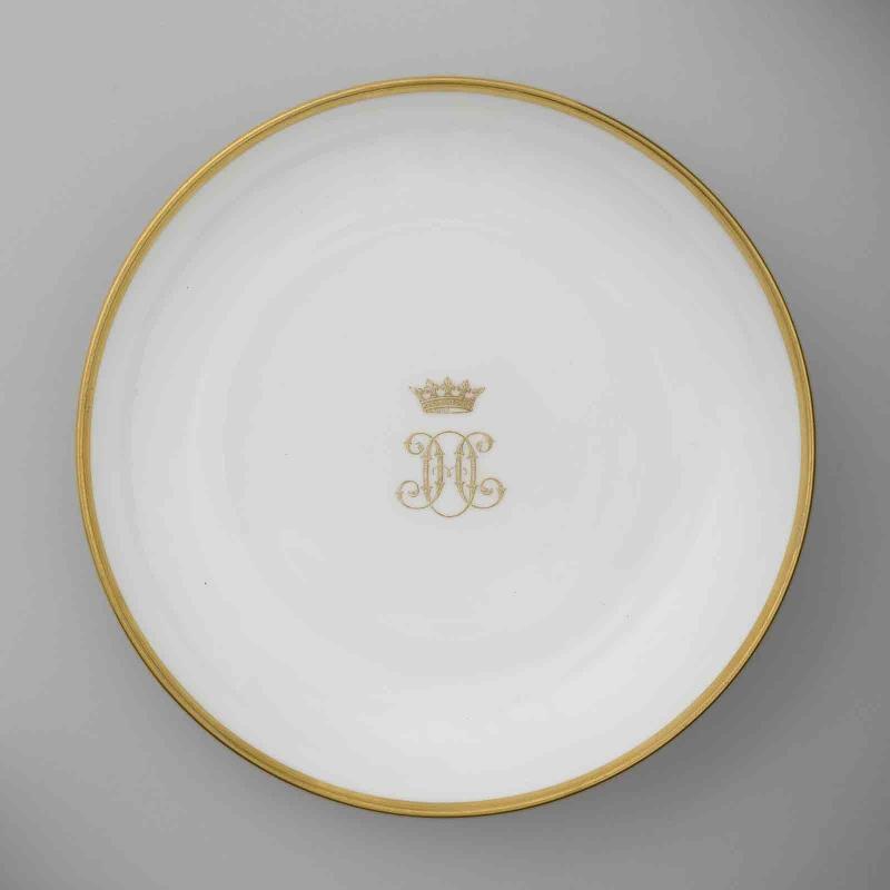 Soucoupe en porcelaine de Sèvres à marli doré au chiffre HO doré et couronné