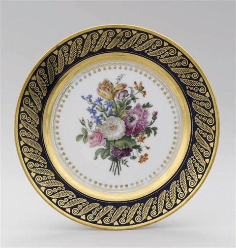 Assiette en porcelaine de Paris, marquée Feuillet au revers, décor floral, marli bleu et or à motif de feuilles