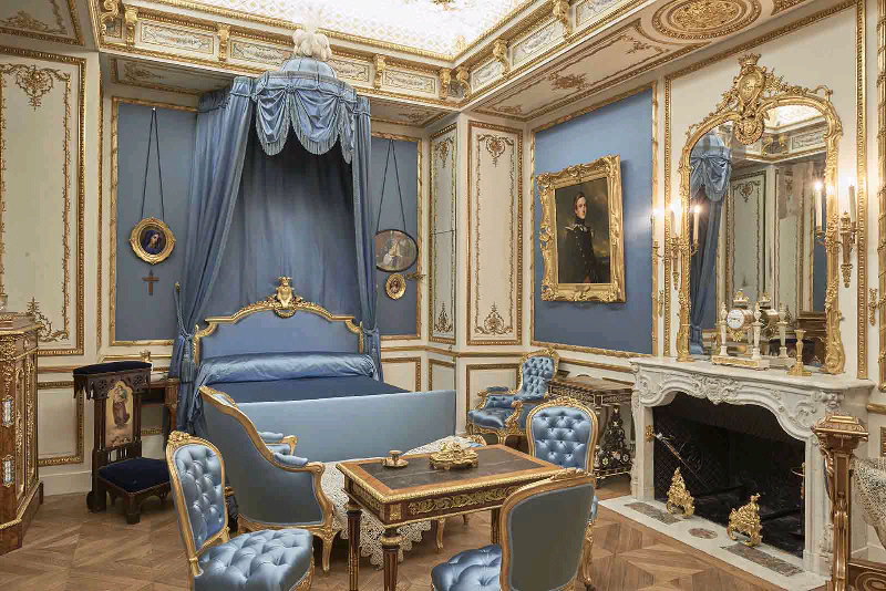 Lit à baldaquin orné de plumes et satin bleu