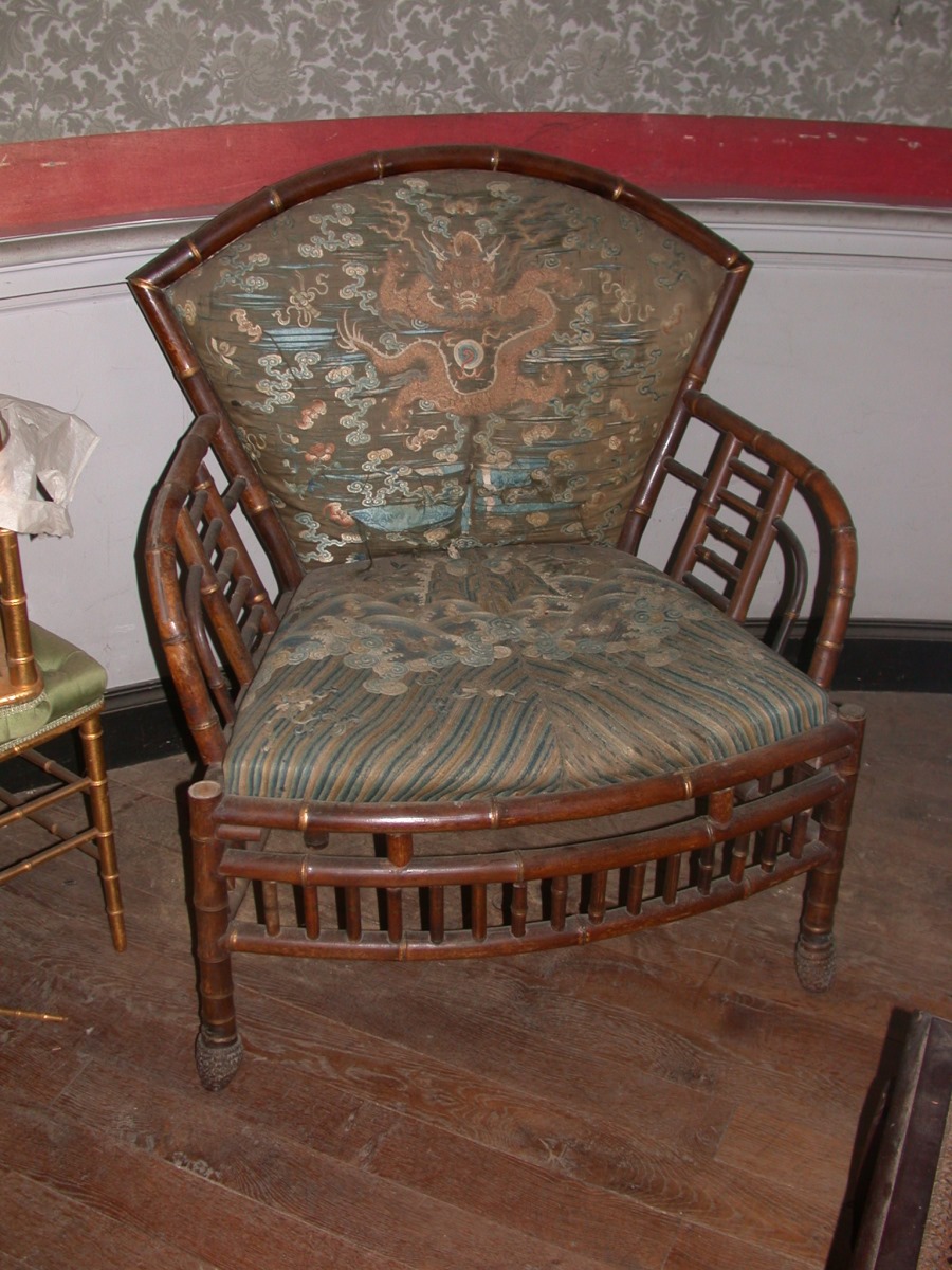 Fauteuil en rotin recouvert de tissu jaune et vert de stryle chinois avec dragon au milieu du dossier