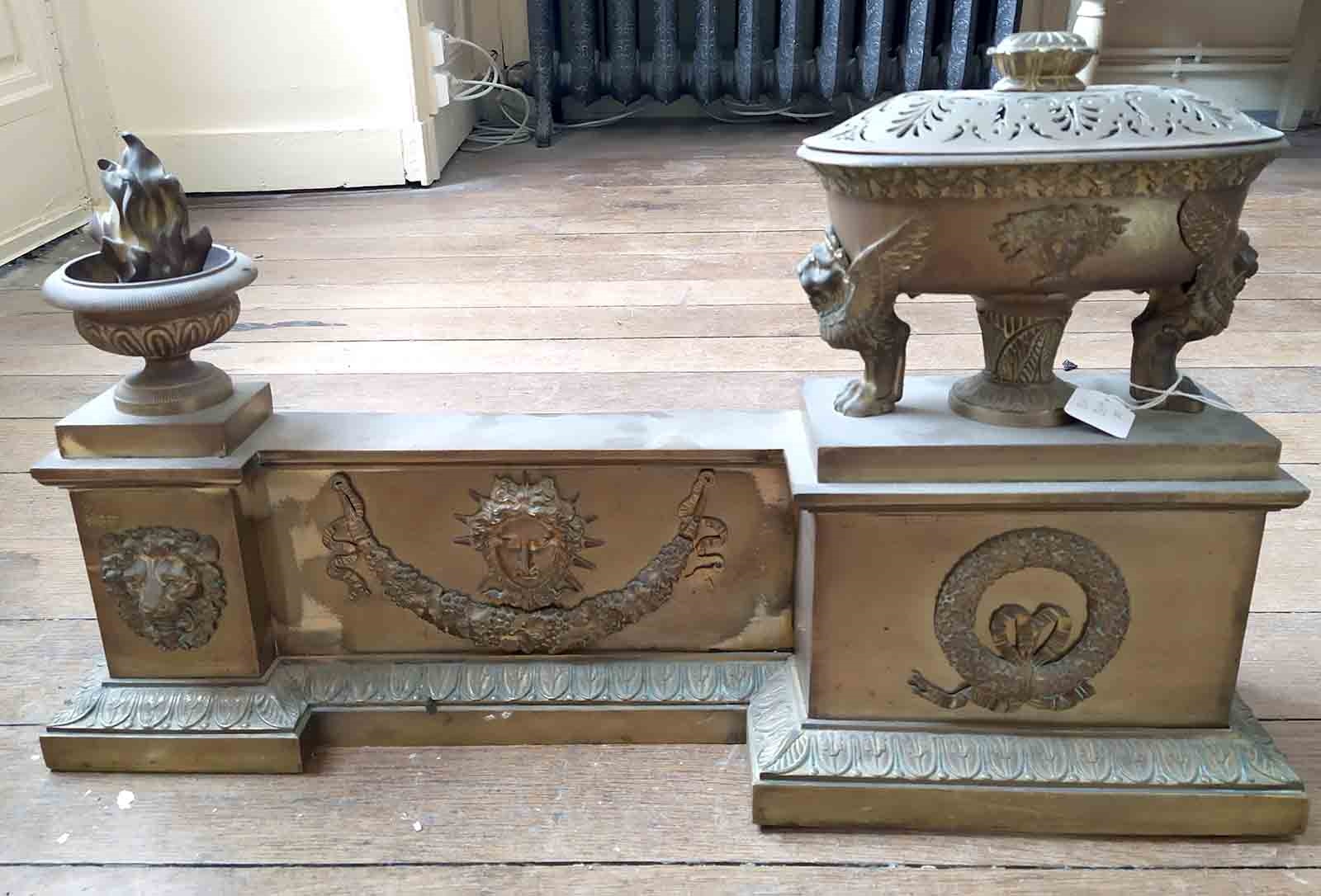 Galerie de cuivre de Style empire en deux parties figurant une cassolettte avec son couvercle, un pot à feu, une tête de lion et une guirlande