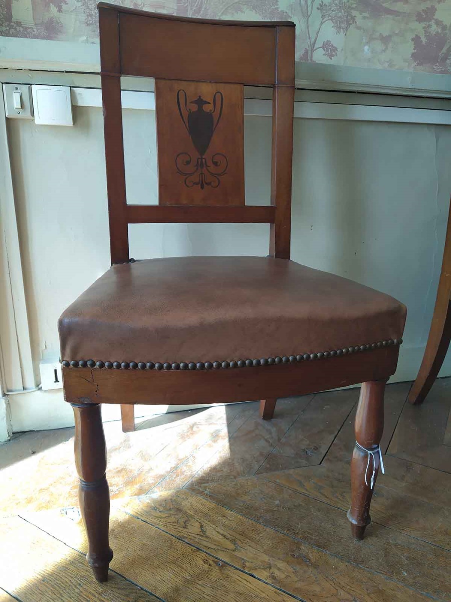 Chaise en noyer et ébène avec dossier incurvé représentant un vase antique et des entrelacs au pied, garnies de moleskine moderne et clous dorés