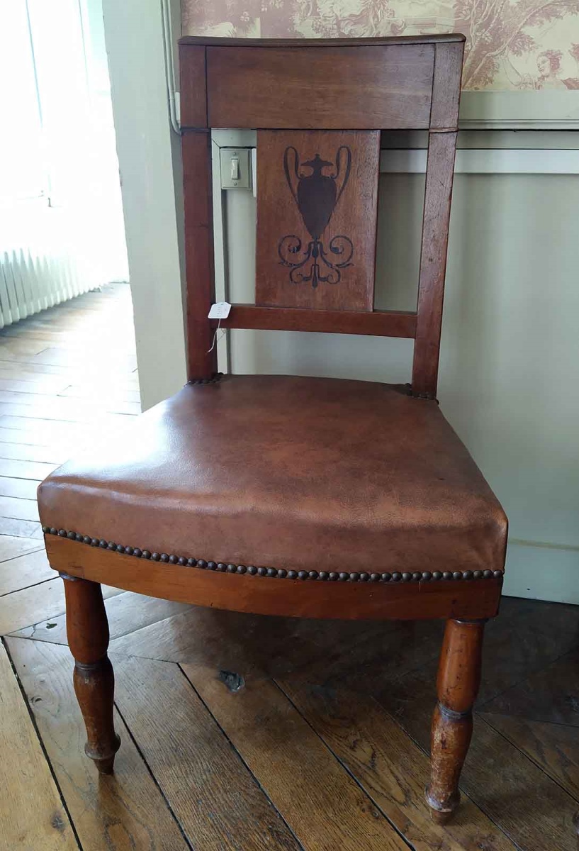 Chaise en noyer et ébène avec dossier incurvé représentant un vase antique et des entrelacs au pied, garnies de moleskine moderne et clous dorés