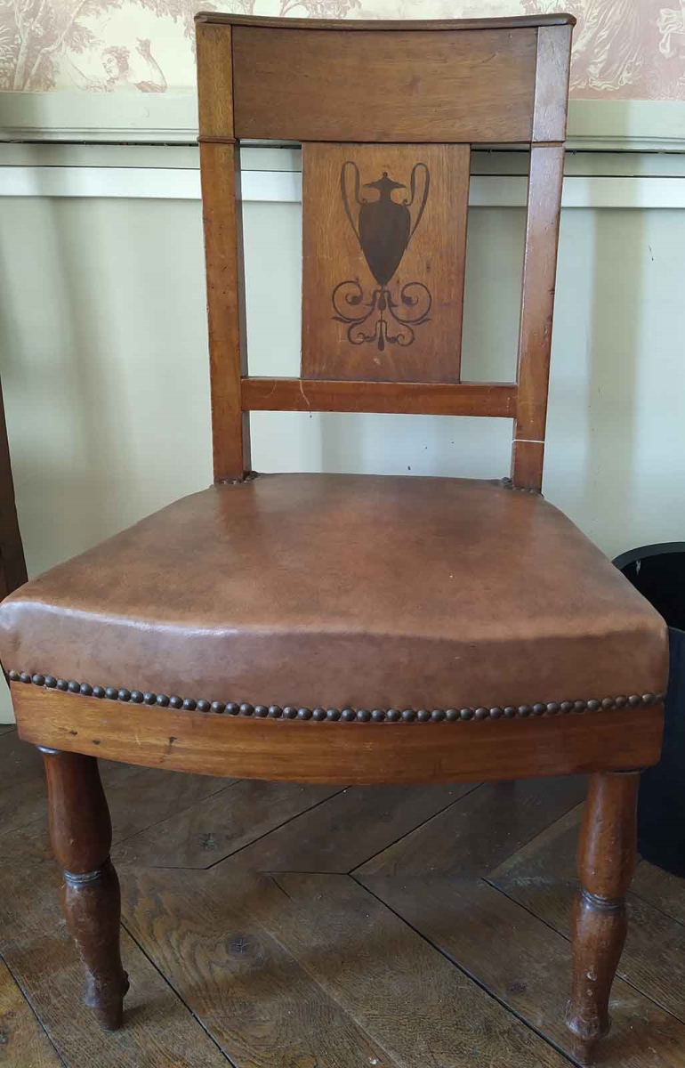 Chaise en noyer et ébène avec dossier incurvé représentant un vase antique et des entrelacs au pied, garnies de moleskine moderne et clous dorés