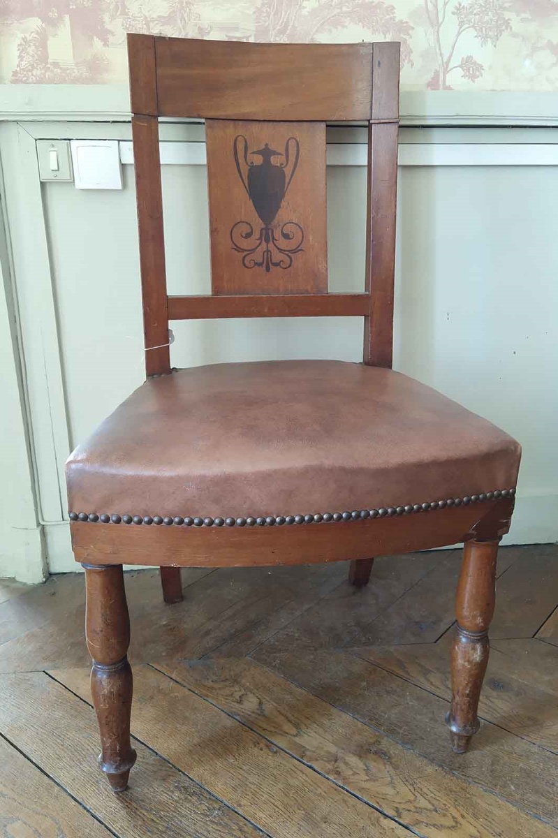 Chaise en noyer et ébène avec dossier incurvé représentant un vase antique et des entrelacs au pied, garnies de moleskine moderne et clous dorés