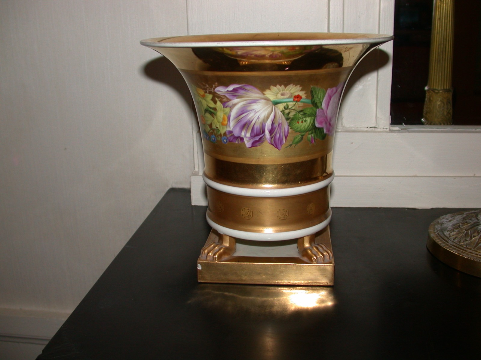 Vase de porcelaine dorée à décor de fleurs reposant sur 4 pattes de lion