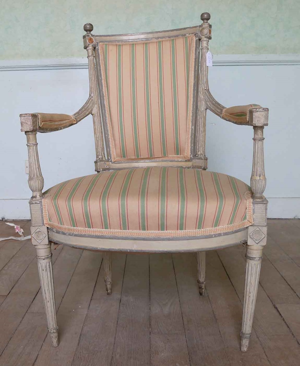 Fauteuil Louis XVI peint en gris clair et recouvert de tissu ocre rose à rayures vertes et rose