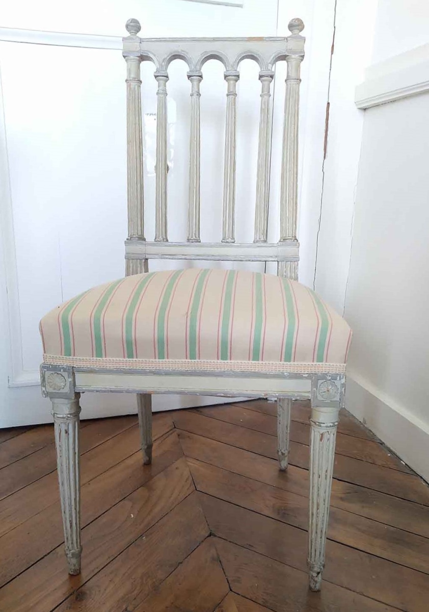 Chaise Louis XVI, dossier à 6 colonnettes, peinte en gris et recouverte de tissu ocre rose à rayures vertes et roses