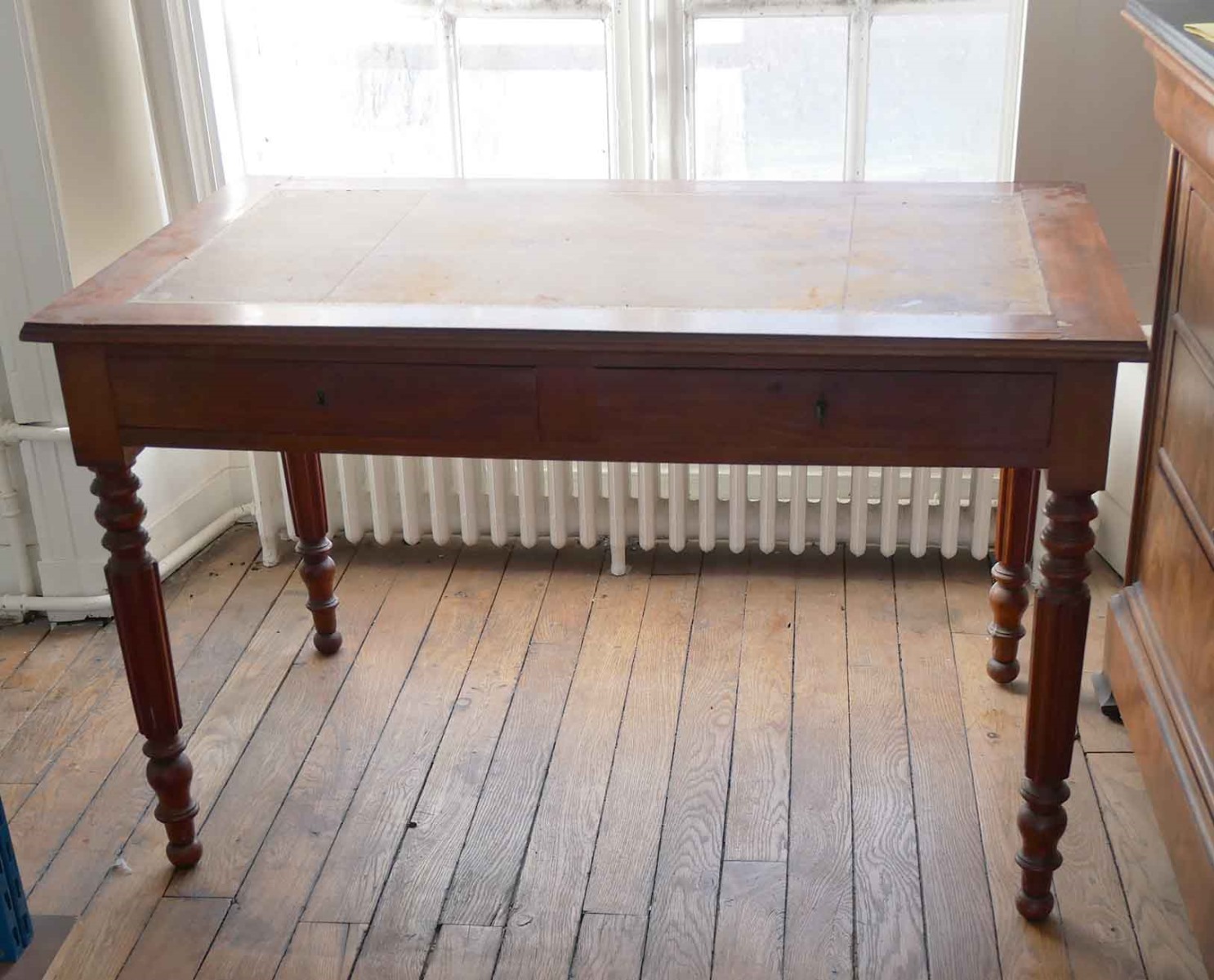 Table pieds cannelés, cuir fauve et deux tiroirs filets dorés