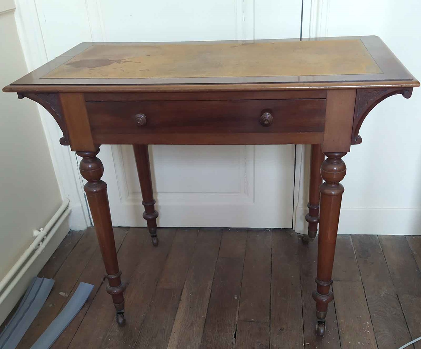 Table recourverte de cuir jaune et or, avec roulettes et tiroir à deux boutons