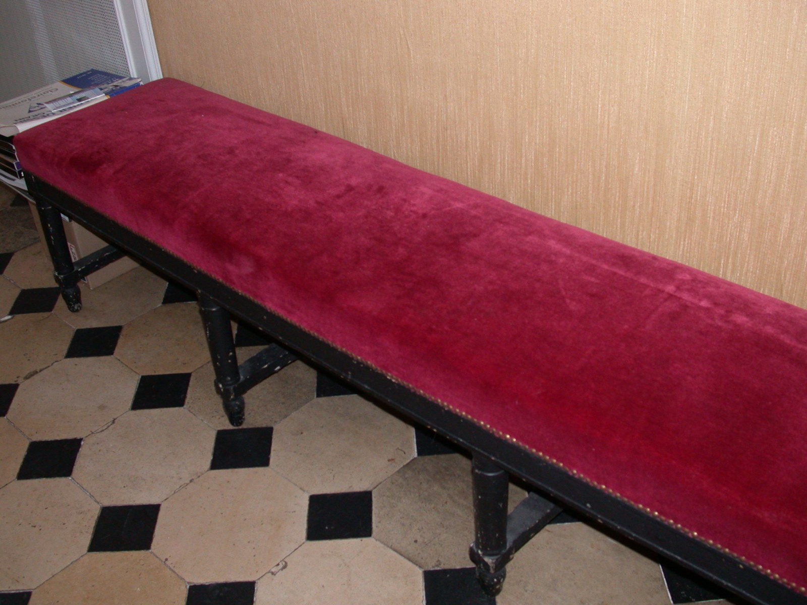 Banquette à 8 pieds en bois peint en noir recourverte de velours rouge